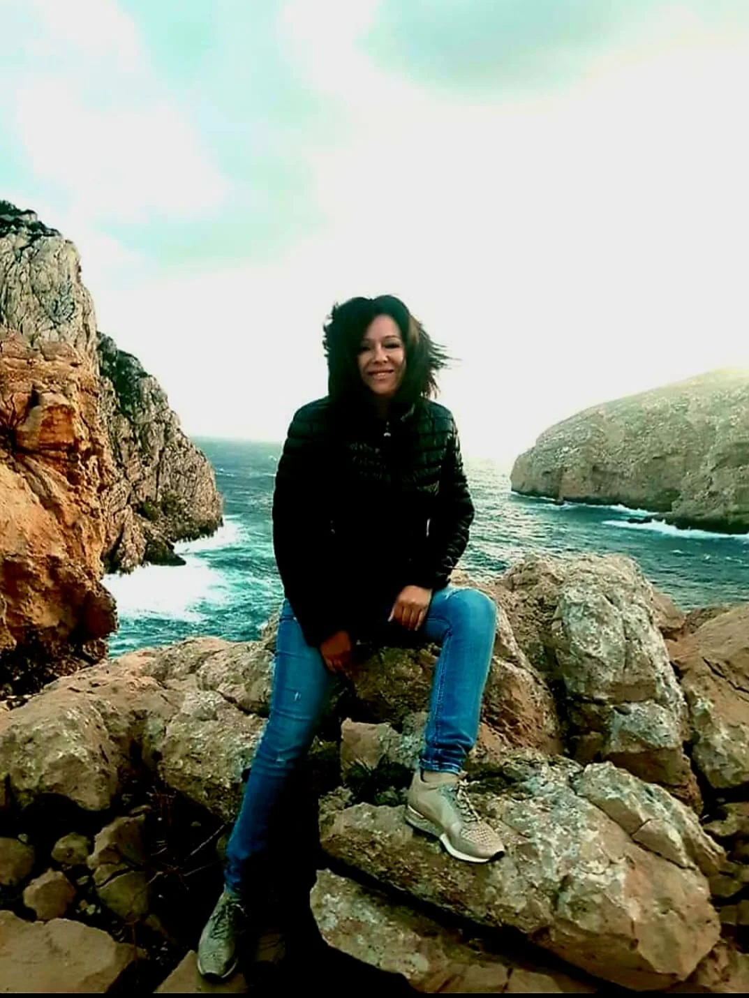 水辺の岩の上に座っている人