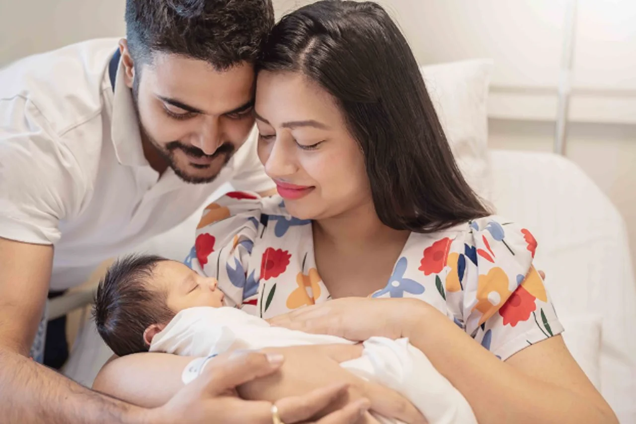a man and woman holding a baby